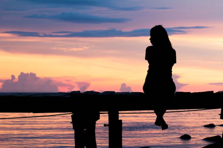 Woman sitting alone on dock