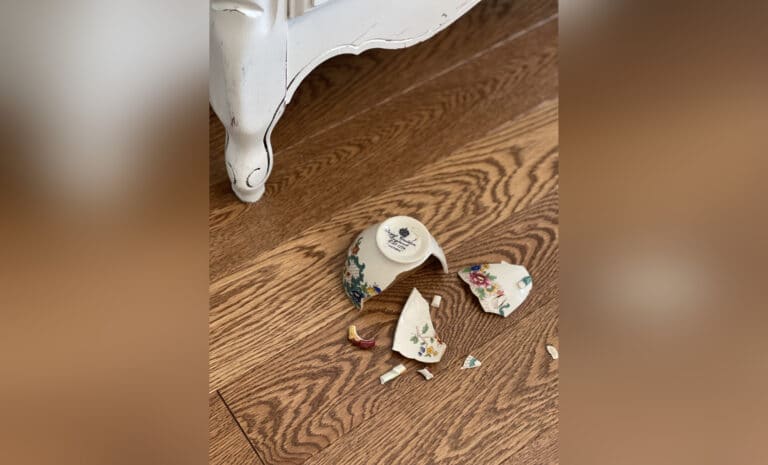 Broken teacup on floor, color photo