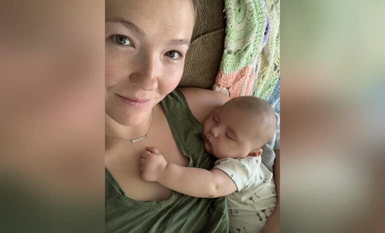 Selfie of mother holding infant, color photo