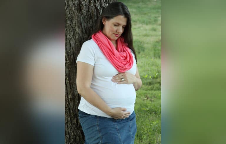 Pregnant woman outside, color photo