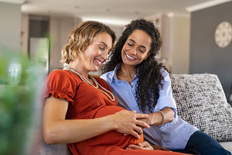 Pregnant woman and friend on couch