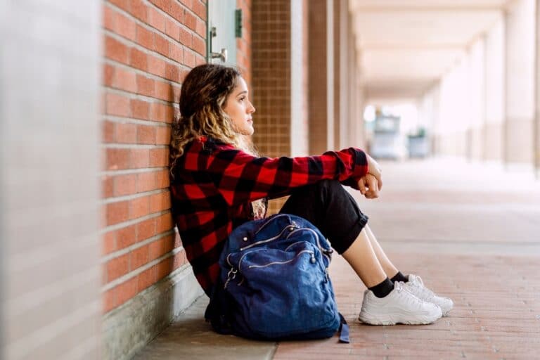 Teen girl at school sitting alone