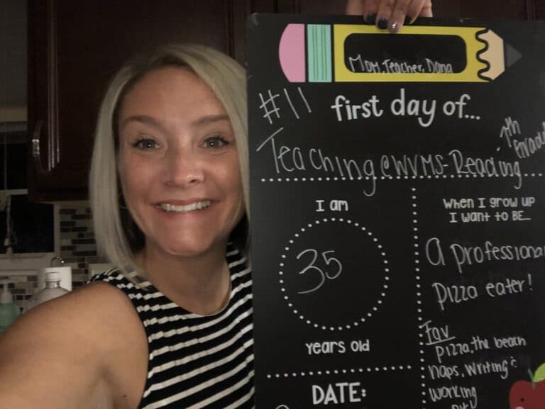 Teacher with first day of school sign, color photo