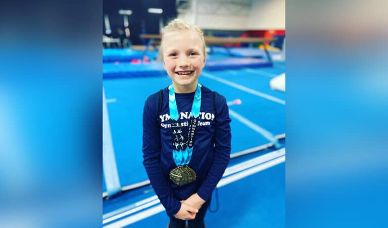 Young girl with gymnastics medal, color photo