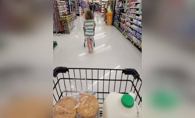 grocery cart with little girl walking ahead