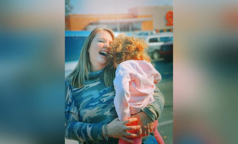 Mother holding child and laughing, color photo