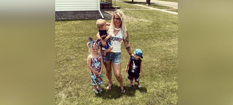 Mother in tank top and shorts with three children, color photo