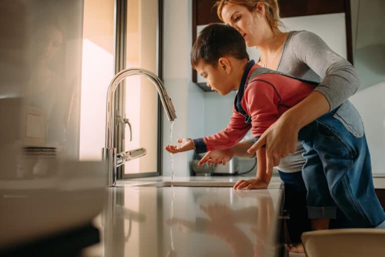 Mother and son washing hands in sink
