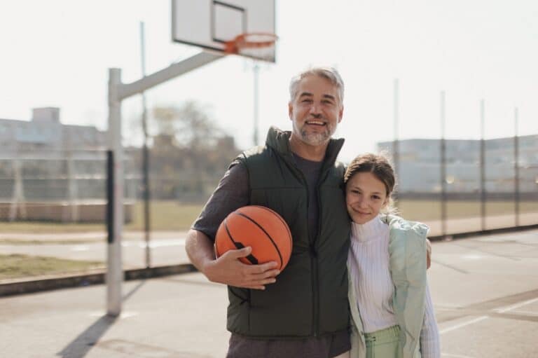 Dad and daughter with basketball smiling