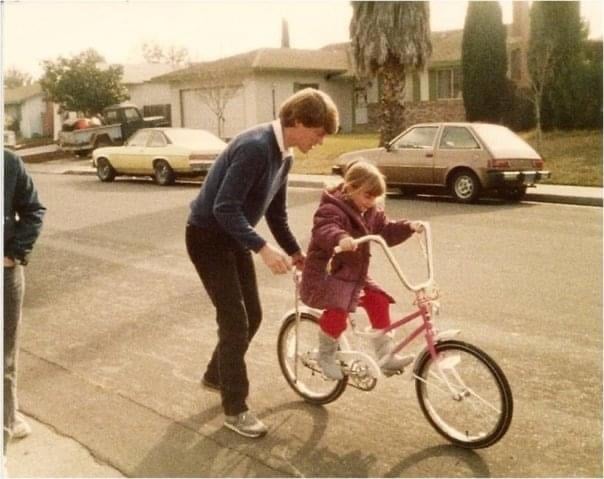 Vintage photo of little girl on bike with her dad