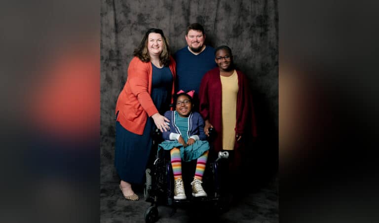 Family picture of mother, father, and two daughters, color photo