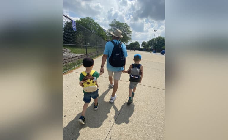 Grandpa walking with two grandsons, color photo
