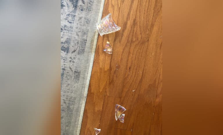 Broken thumbprint glass on floor, color photo