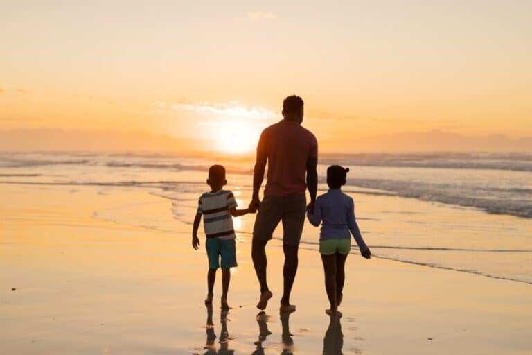 Dad and kids walking on beach