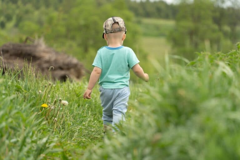Child walking away in grass
