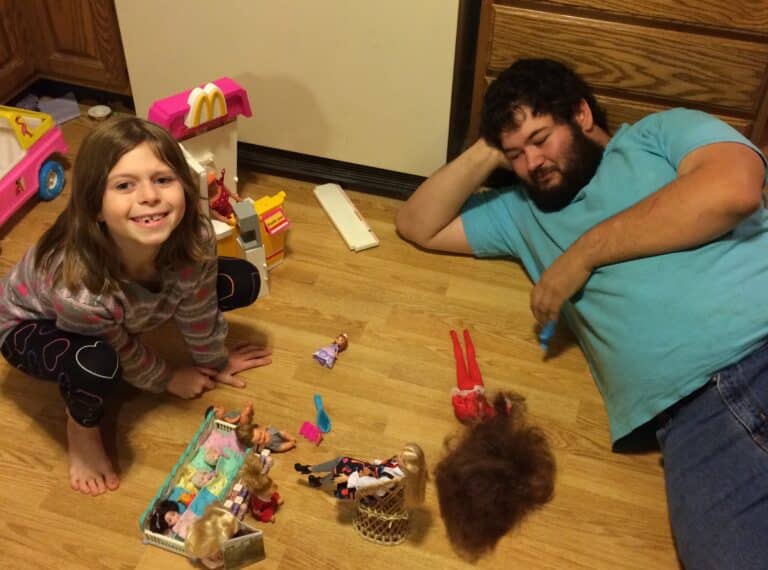 Man and girl play dolls on the floor