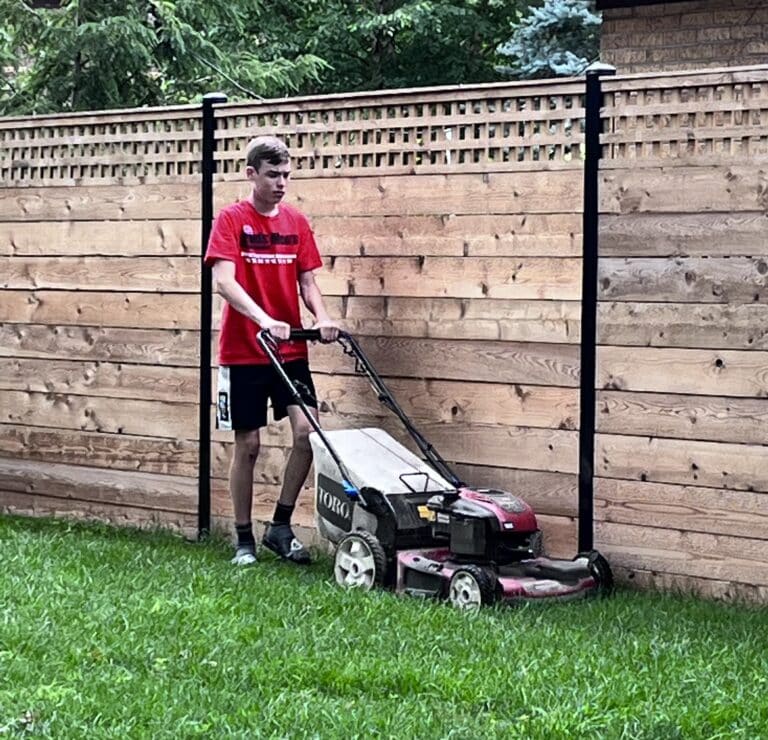 Teen boy mowing lawn