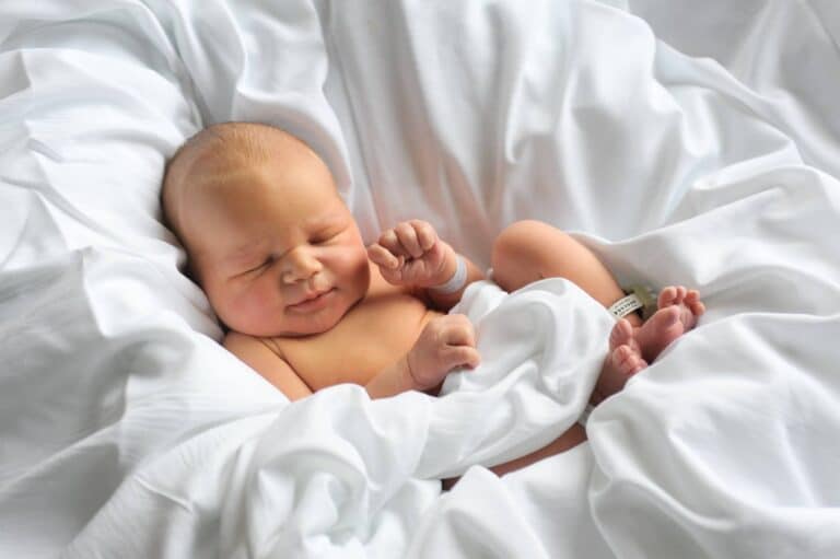 Newborn photo in white bedding, color photo