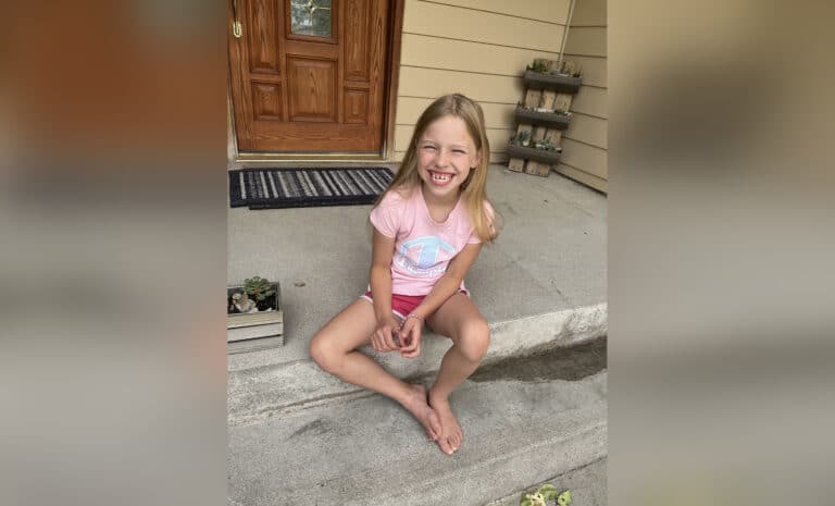 Little girl smiling on porch