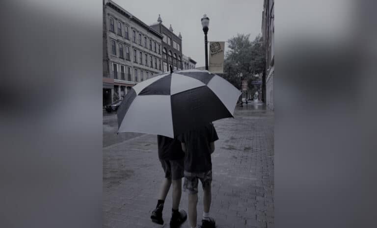 two boys under an umbrella