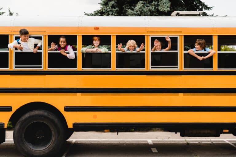 Kids waving from school bus