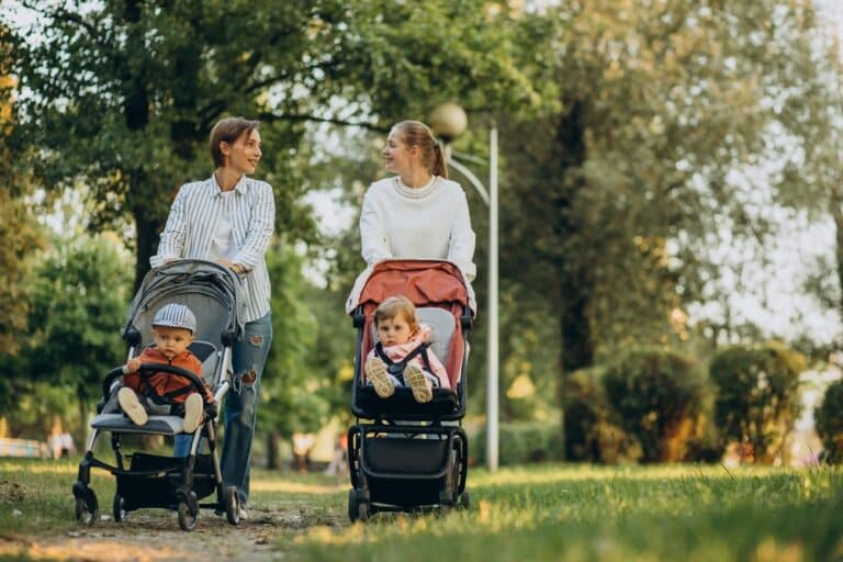 Two women walking with babies in strollers