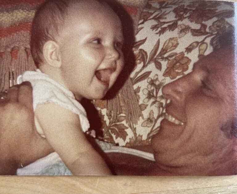 Man holding smiling infant, color photo