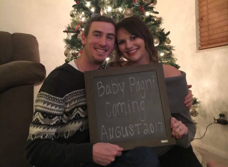 Couple holding baby announcement