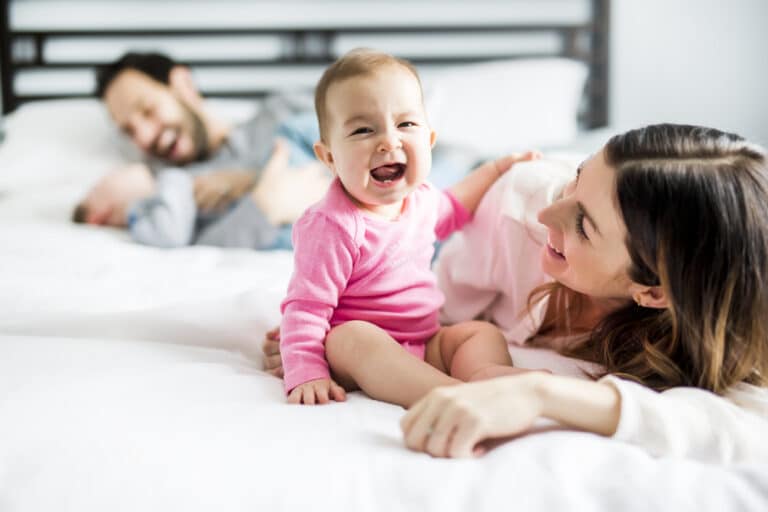 Family of four with baby and toddler on bed