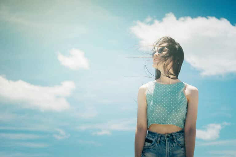 Woman smiling in front of blue sky