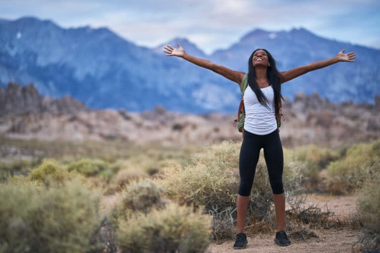 Woman hiking with arms wide