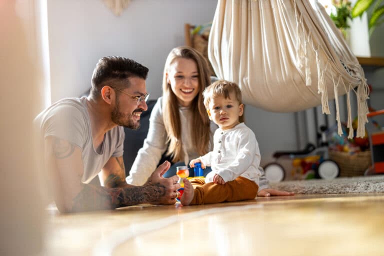Mom and dad with child playing on floor