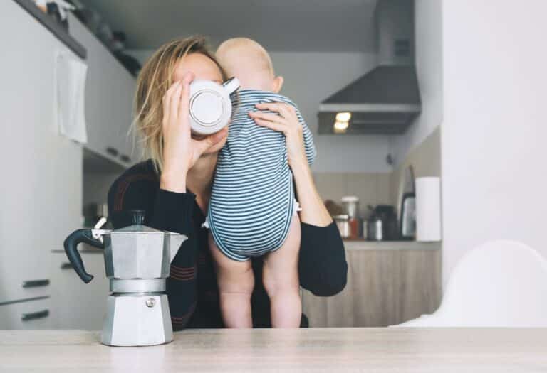 Tired mom with baby drinking coffee