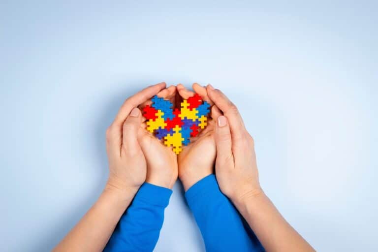 Autism heart puzzle piece symbol in hands