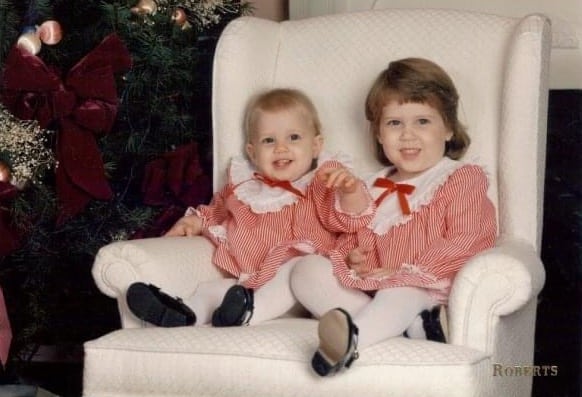 Little girls in Christmas dresses sitting in white chair