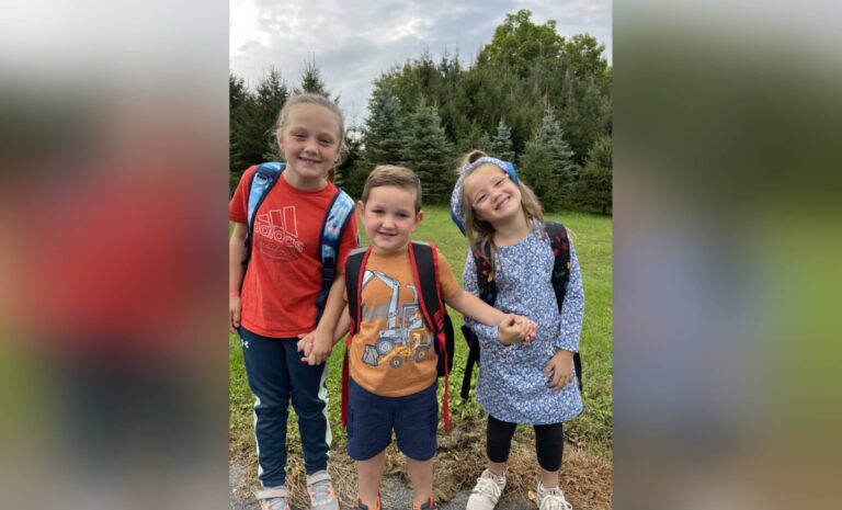 Three kids with backpacks, color photo
