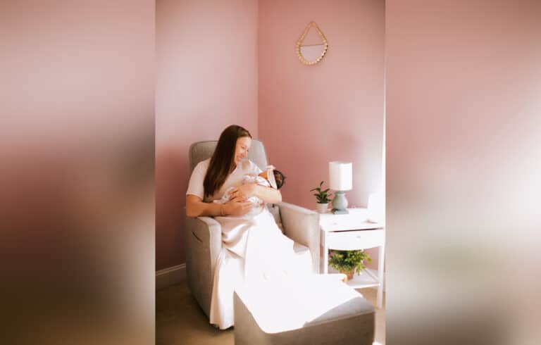 Mother holding baby in nursery, color photo