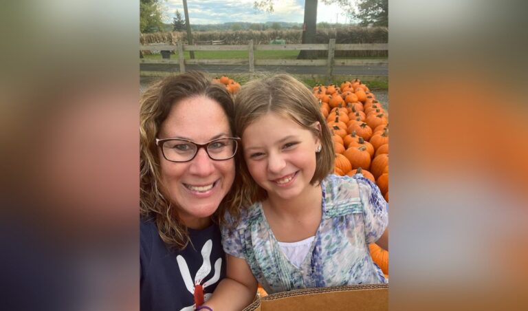 Young girl and her mom at pumpkin patch, color photo