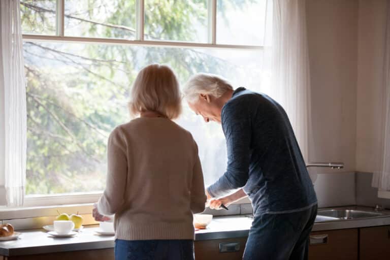 Older couple in kitchen smiling