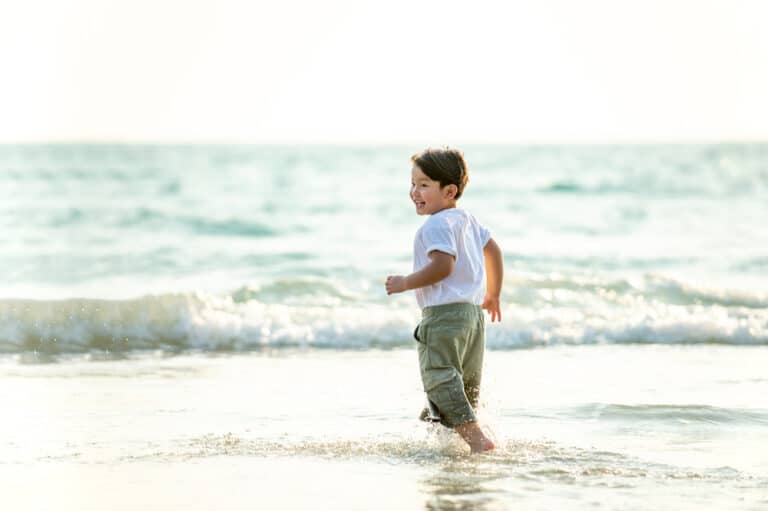 Little boy in shallow water of beach