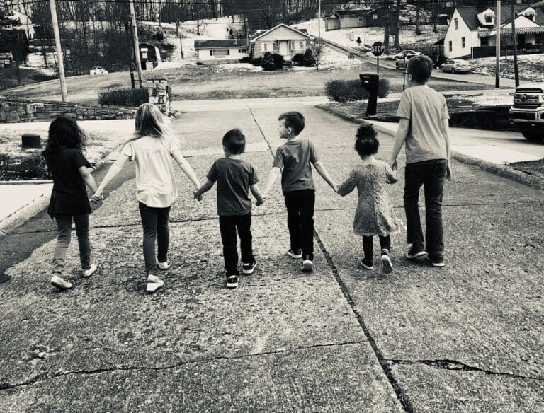 Six children holding hands, black-and-white photo