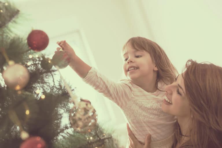 Mother and daughter decorate Christmas tree