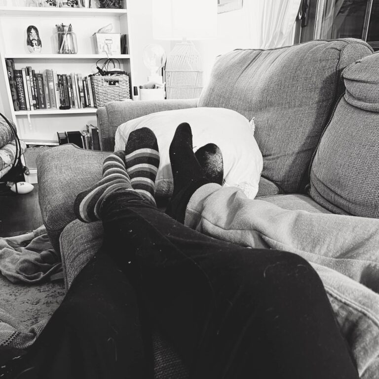 photo of two people's feet on a couch