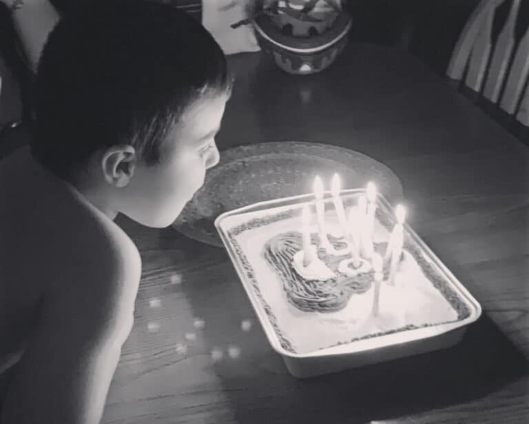 Boy blowing out candles on cake