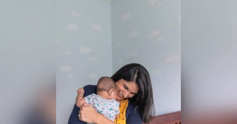Woman hugging infant, color photo