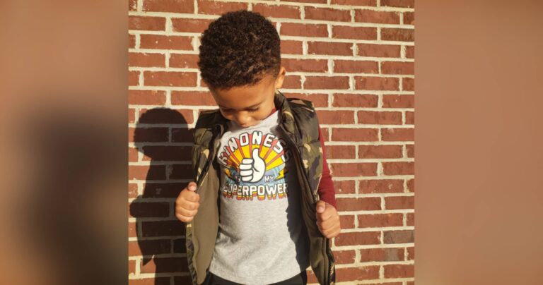 Little boy wearing shirt that says Kindness, color photo