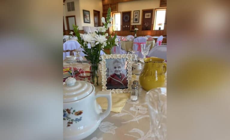 Table set as a tea party with framed picture of a woman, color photo