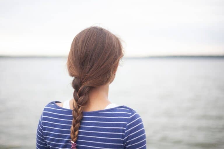 Back of woman's head and braid looking at water
