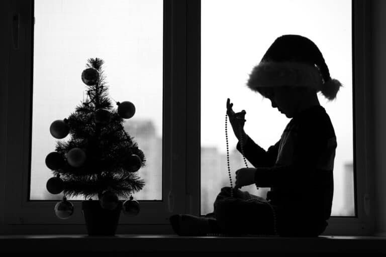 Silhouette of child and small Christmas tree