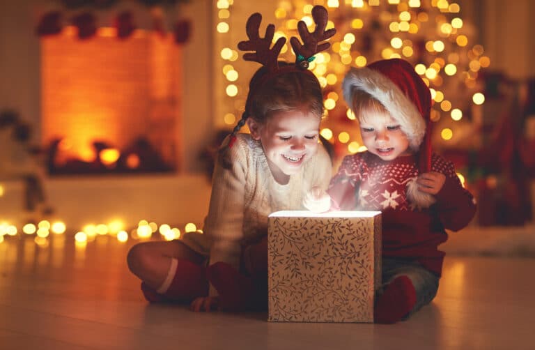 Kids looking in Christmas present with lights
